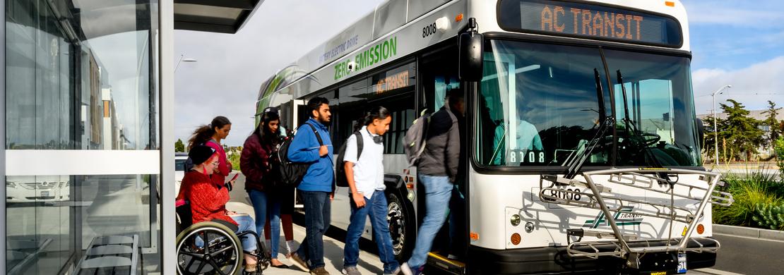 A group of people boarding an AC Transit bus