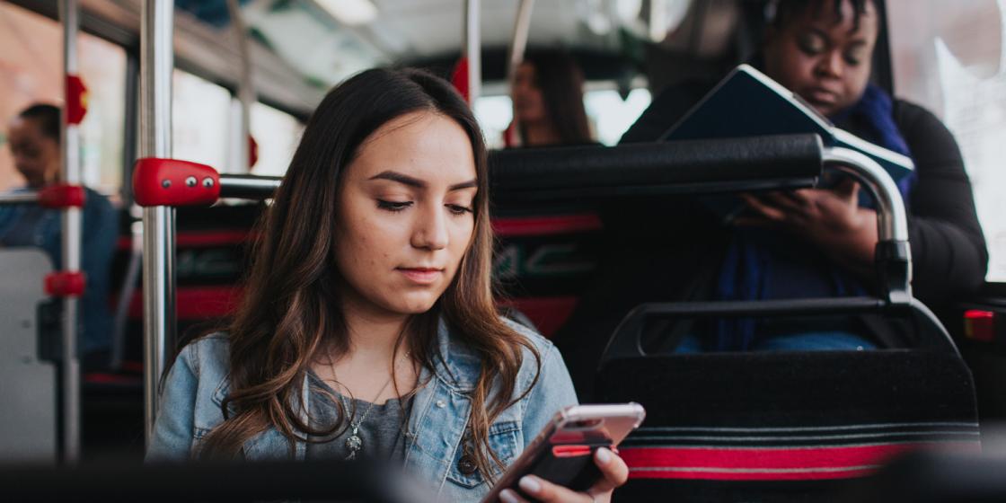 Woman looking at phone, while riding the bus